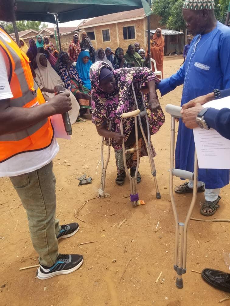 TLM donating crutches to a leper